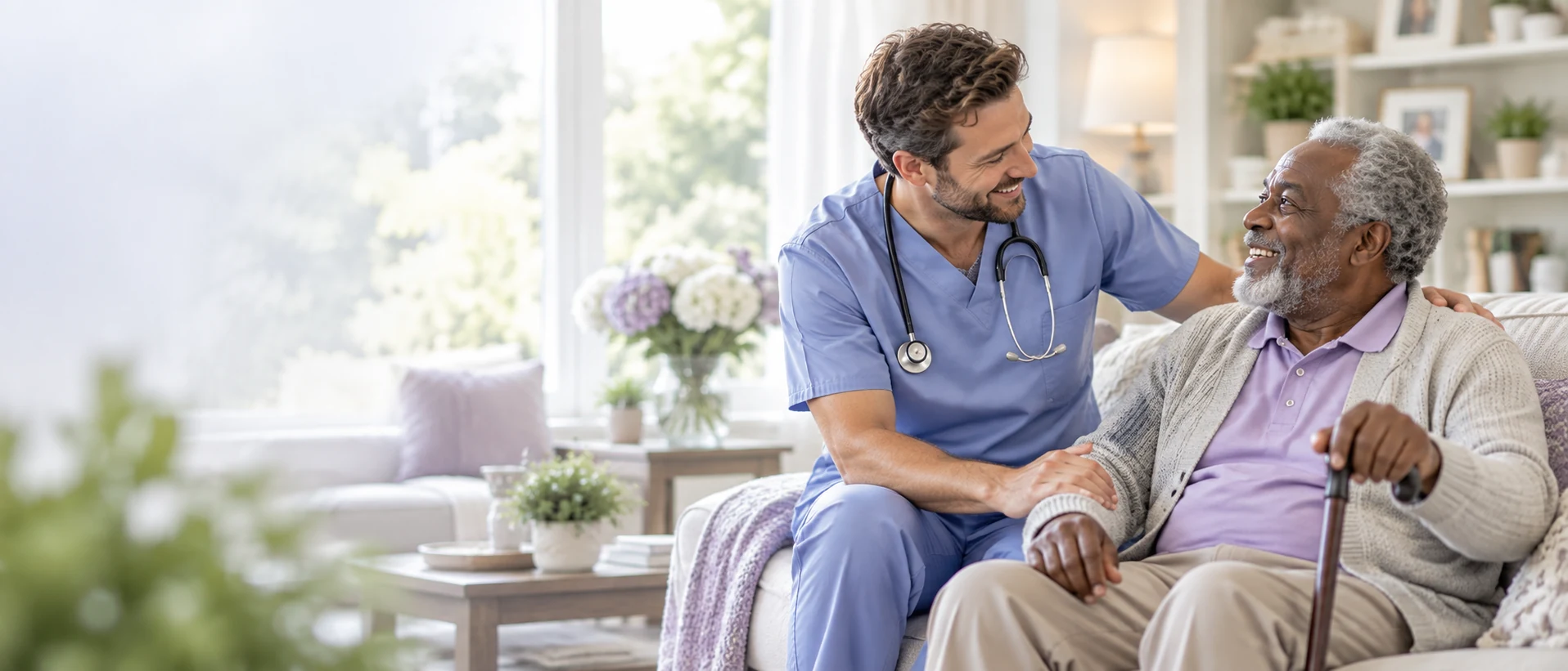 Male home health nurse supporting an older adult in a bright living room